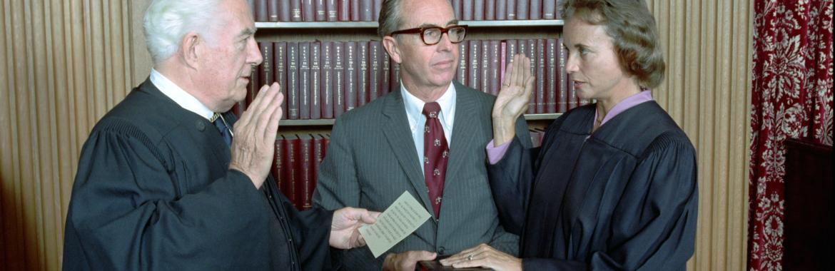 Sandra Day O'Connor being sworn in as a Supreme Court Justice by Chief Justice Warren Burger as her husband John O'Connor looks on, September 25, 1981. (NAID 276563289)