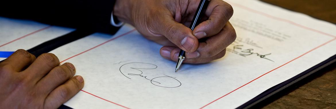 President Barack Obama signs a bill in the Oval Office, April 7, 2010.