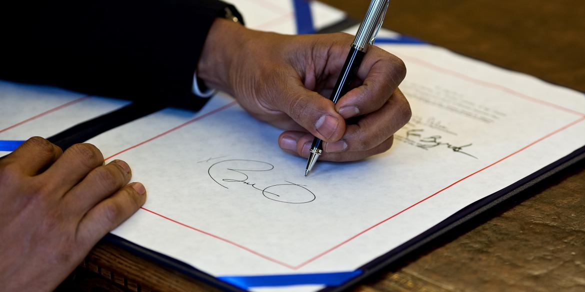 President Barack Obama signs a bill in the Oval Office, April 7, 2010.